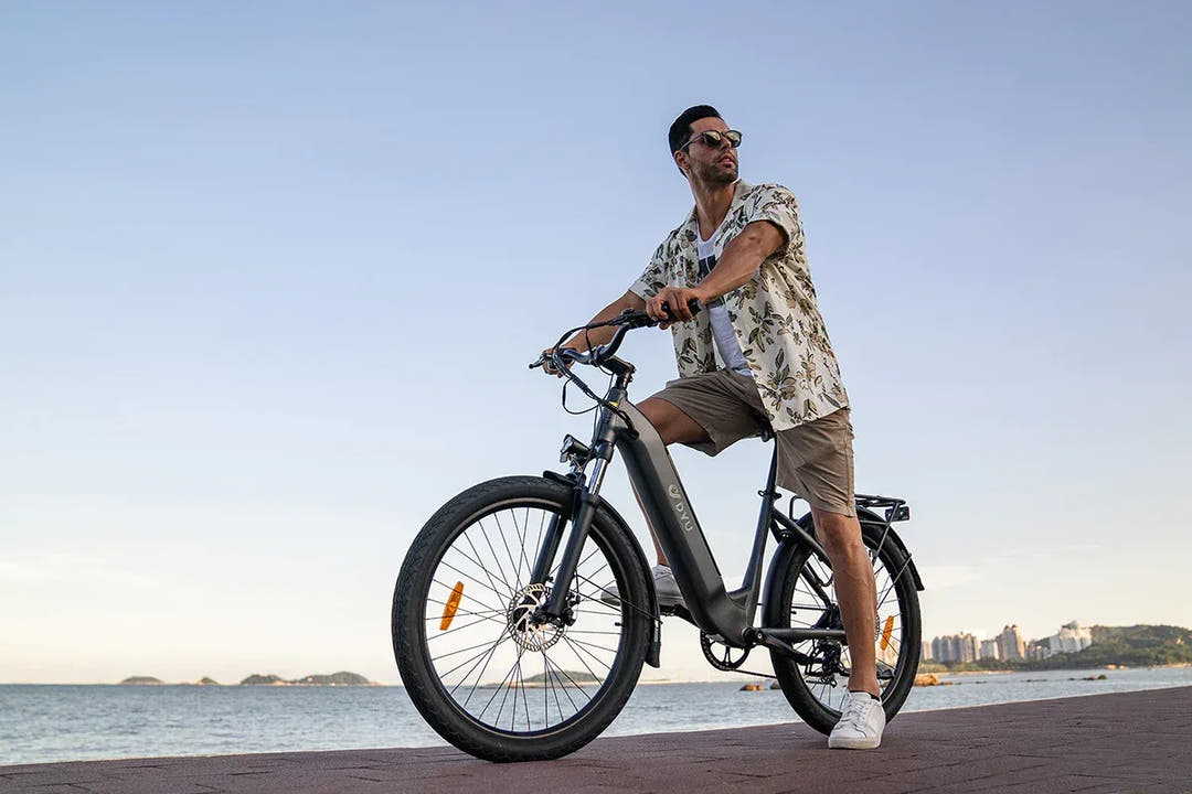 DYU C1 City E-Bike with rider near beech